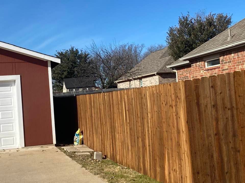 A wooden fence is surrounding a garage in a residential area.
