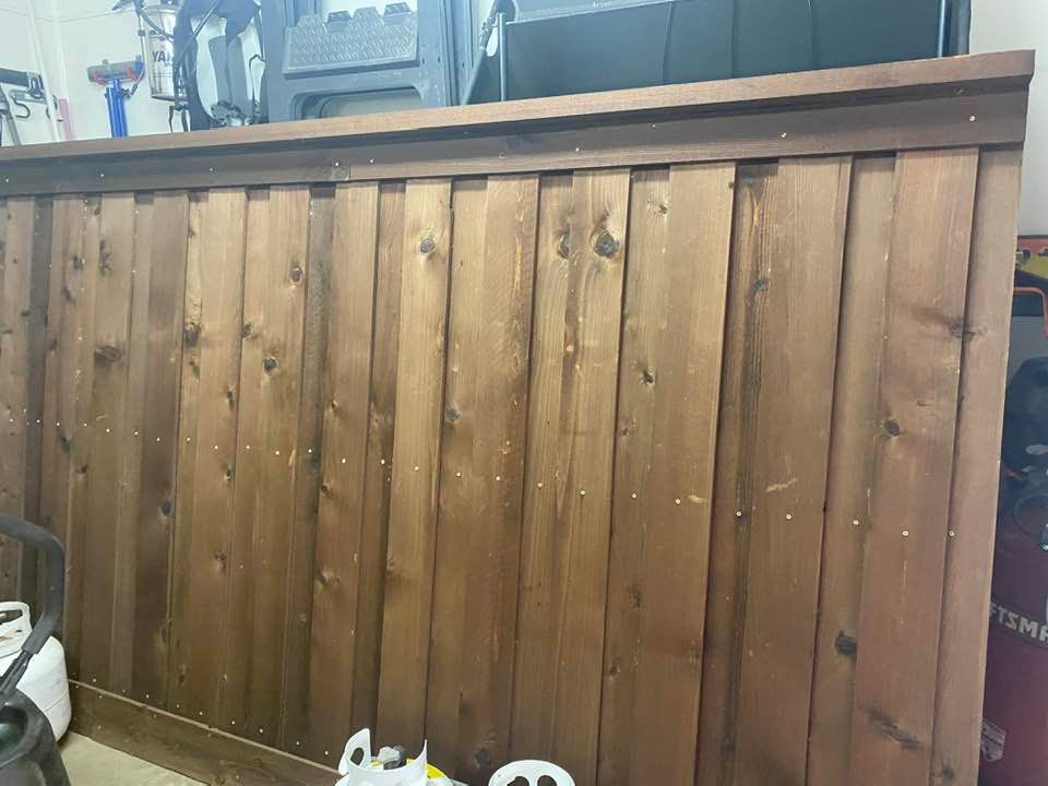 A wooden fence is sitting in a room next to a vacuum cleaner.