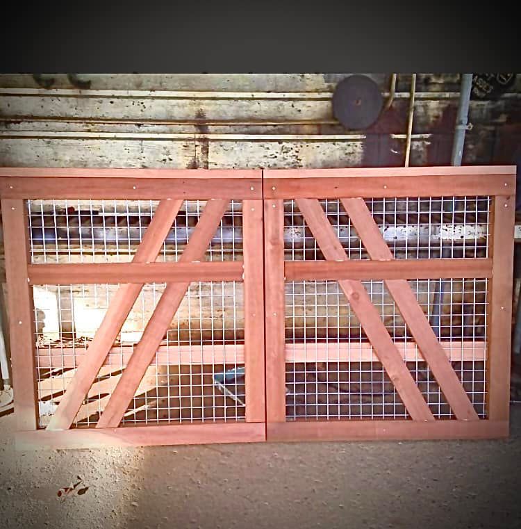 A pair of wooden gates with a fence around them
