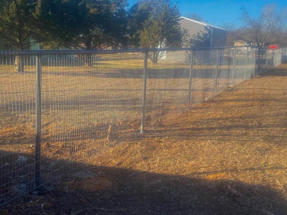 There is a fence in the middle of a field.
