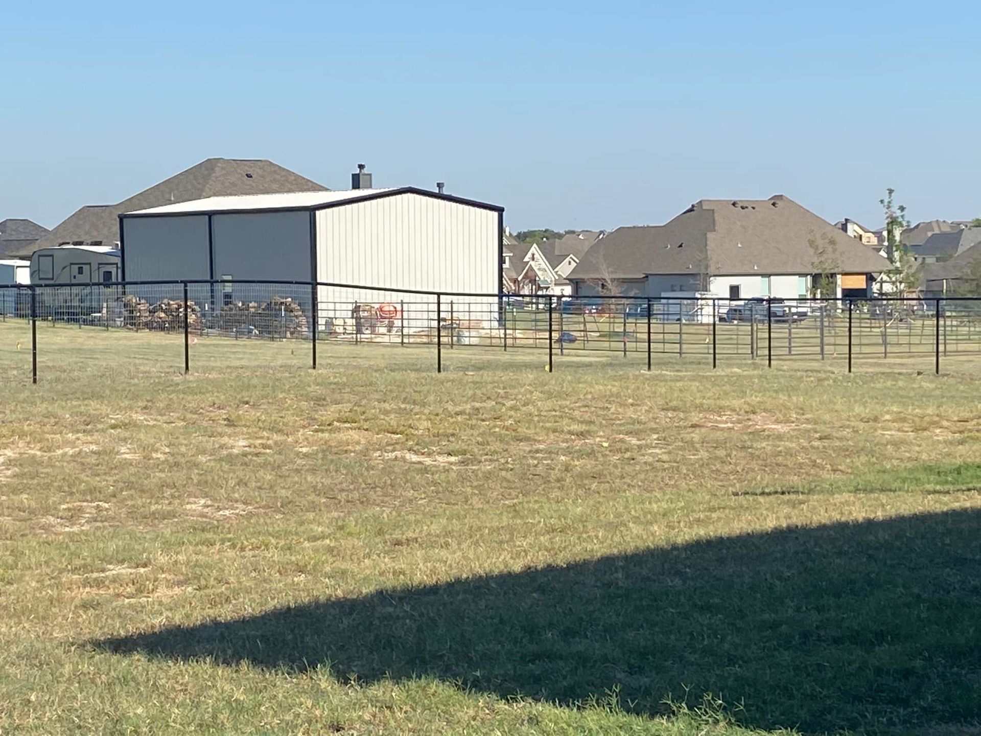 A fenced in field with a building in the background