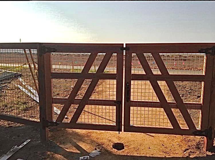A wooden gate with a fence in the background