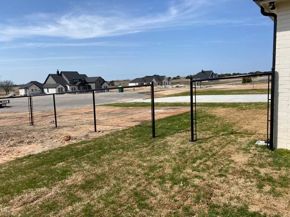 There is a fence in the backyard of a house.