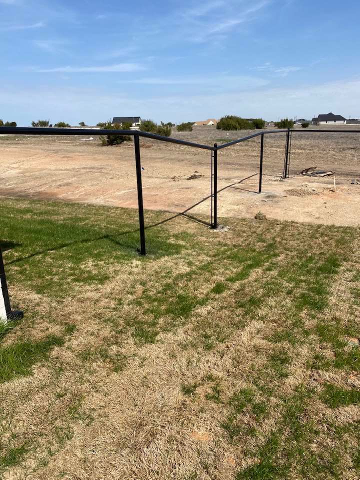 A soccer goal is sitting in the middle of a field.