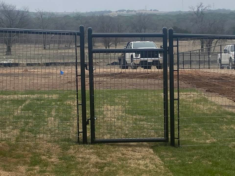 A fence with a gate and a truck in the background