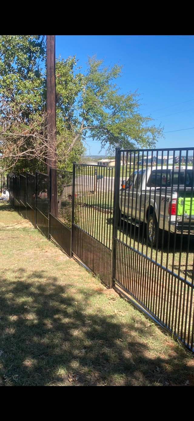 A metal fence with a truck parked behind it.