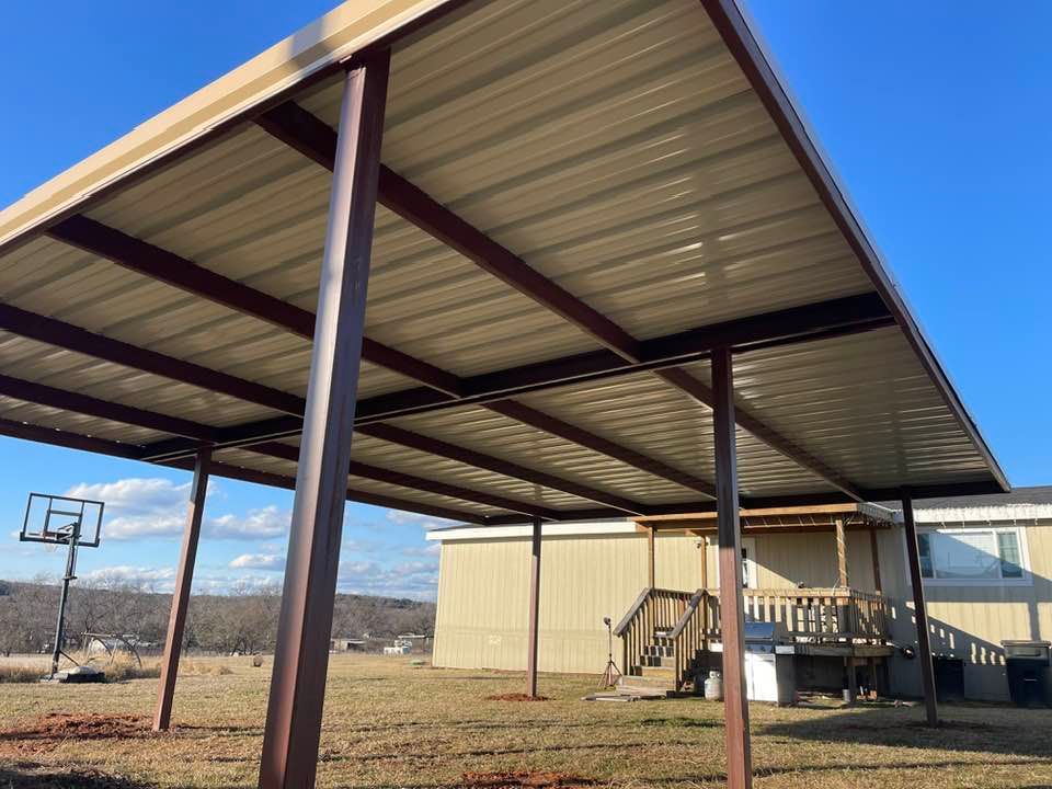 A carport with a basketball hoop underneath it in front of a house.