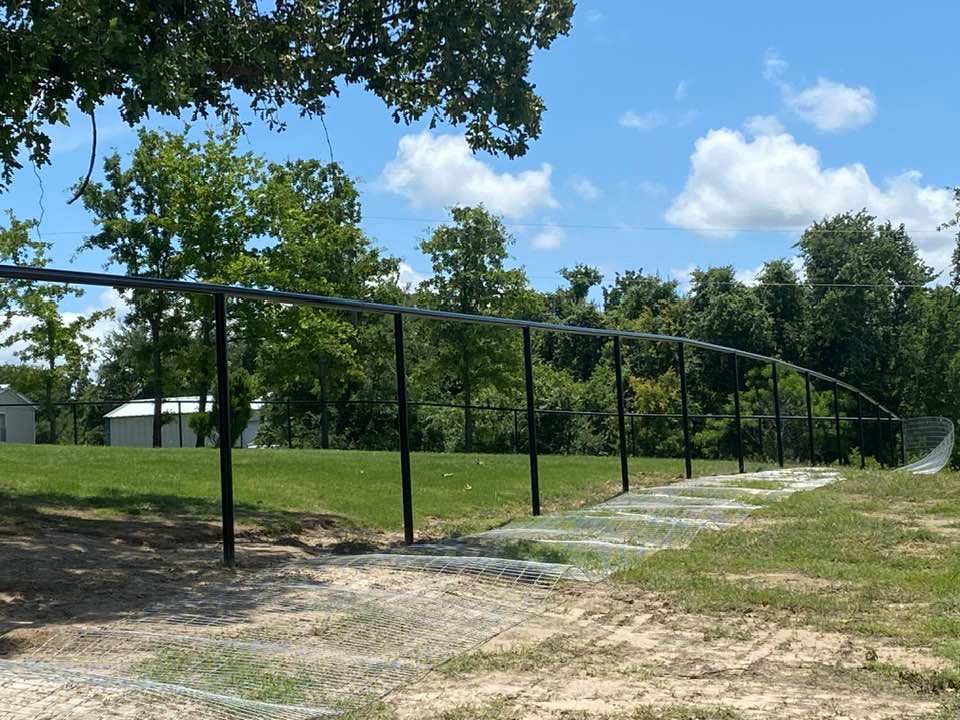 A fence in a field with trees in the background
