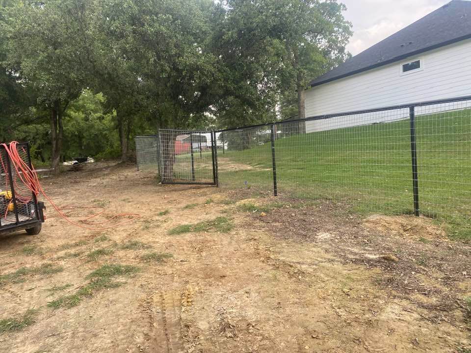 A fence is being built in the backyard of a house.