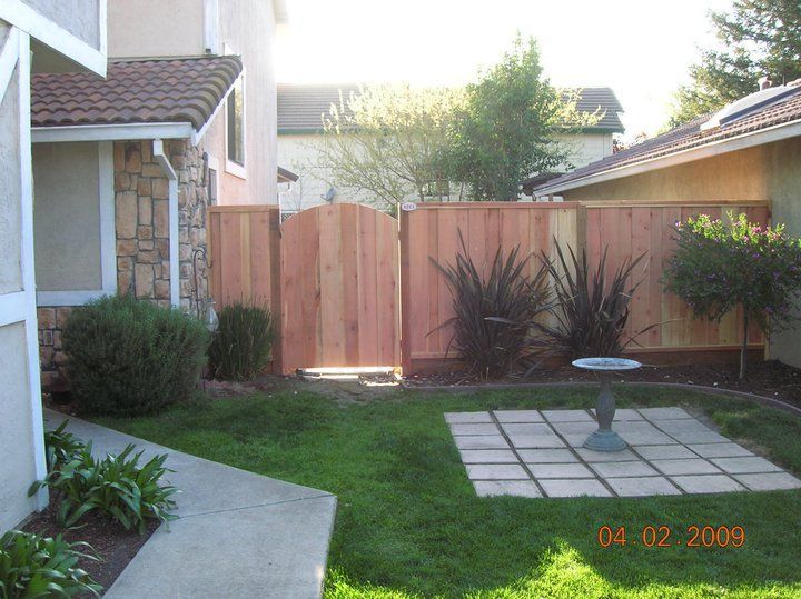 A house with a wooden fence and a bird bath