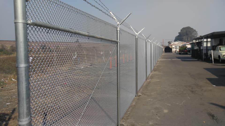 A chain link fence with barbed wire on top of it