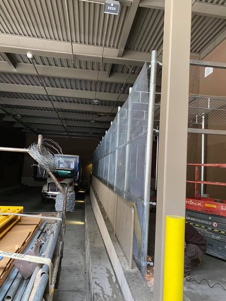 A fence is being built in a building next to a yellow pole.