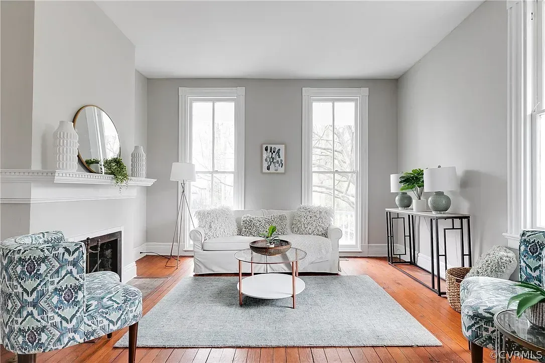 A living room with a couch , chairs , coffee table and fireplace.