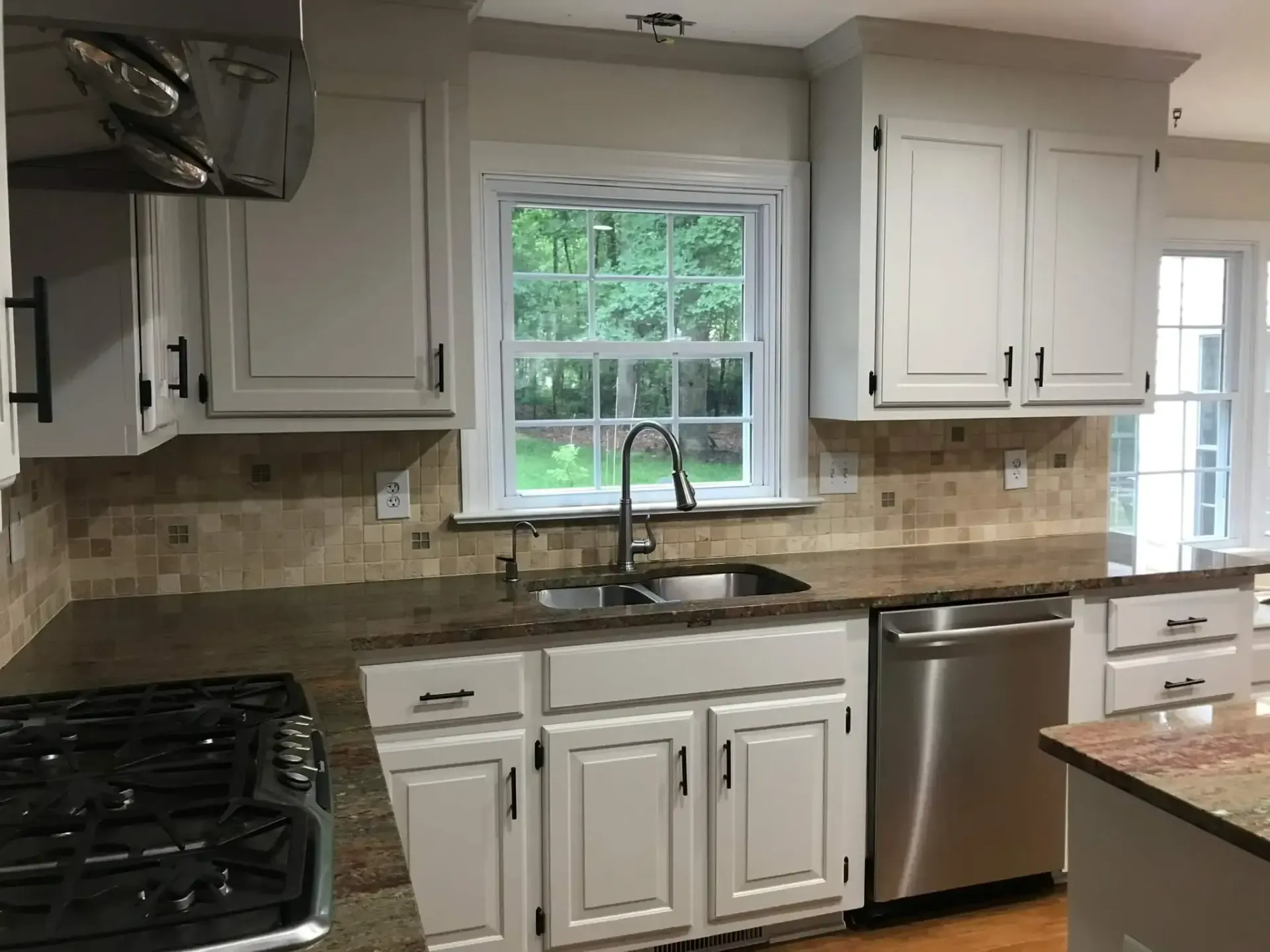 A kitchen with white cabinets and stainless steel appliances