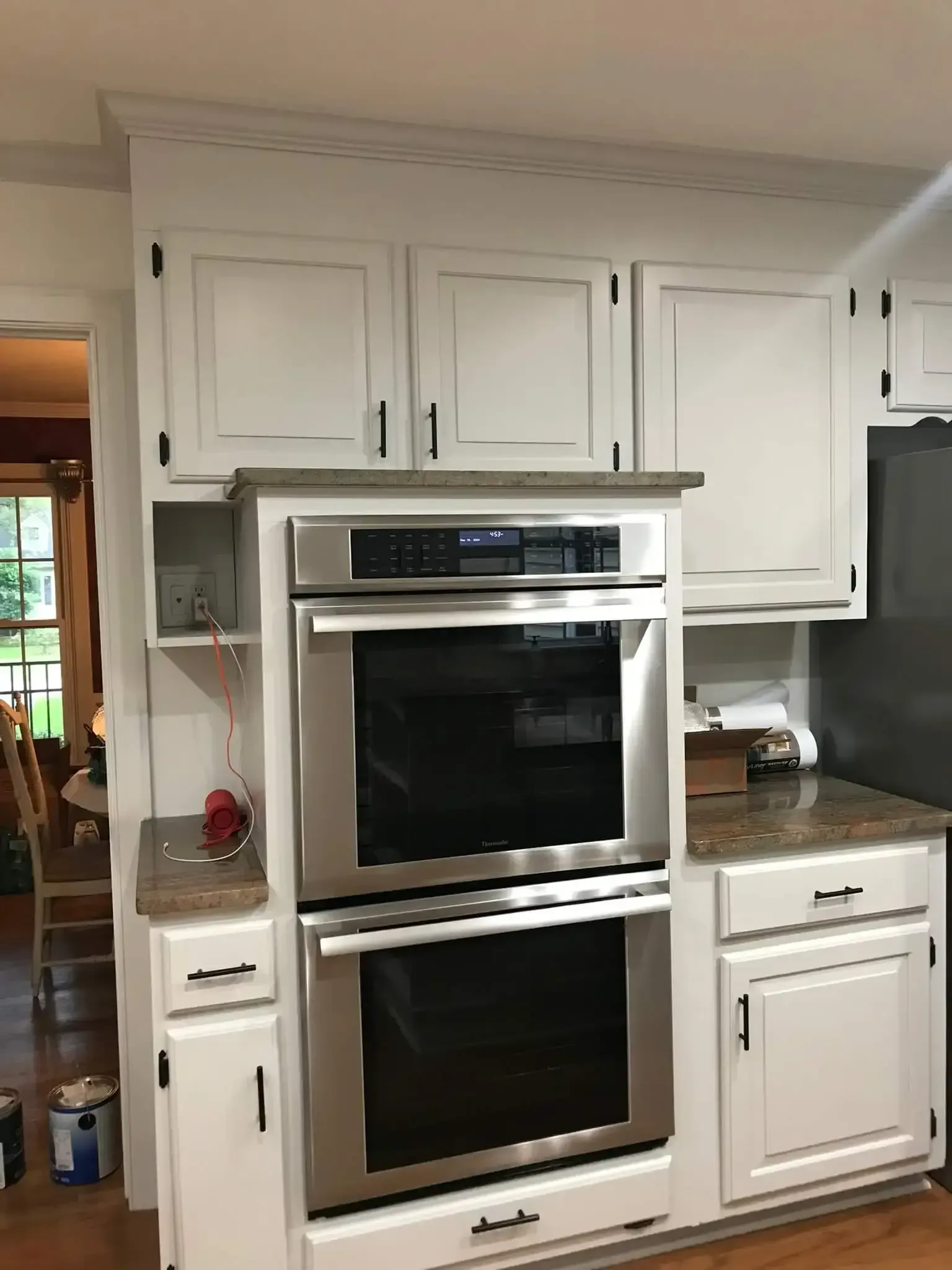 A kitchen with white cabinets and stainless steel appliances.