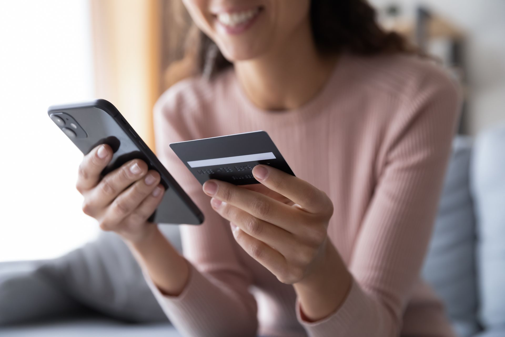 A women holding a phone and credit card