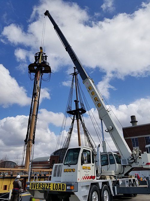 A large crane is lifting a pirate ship.