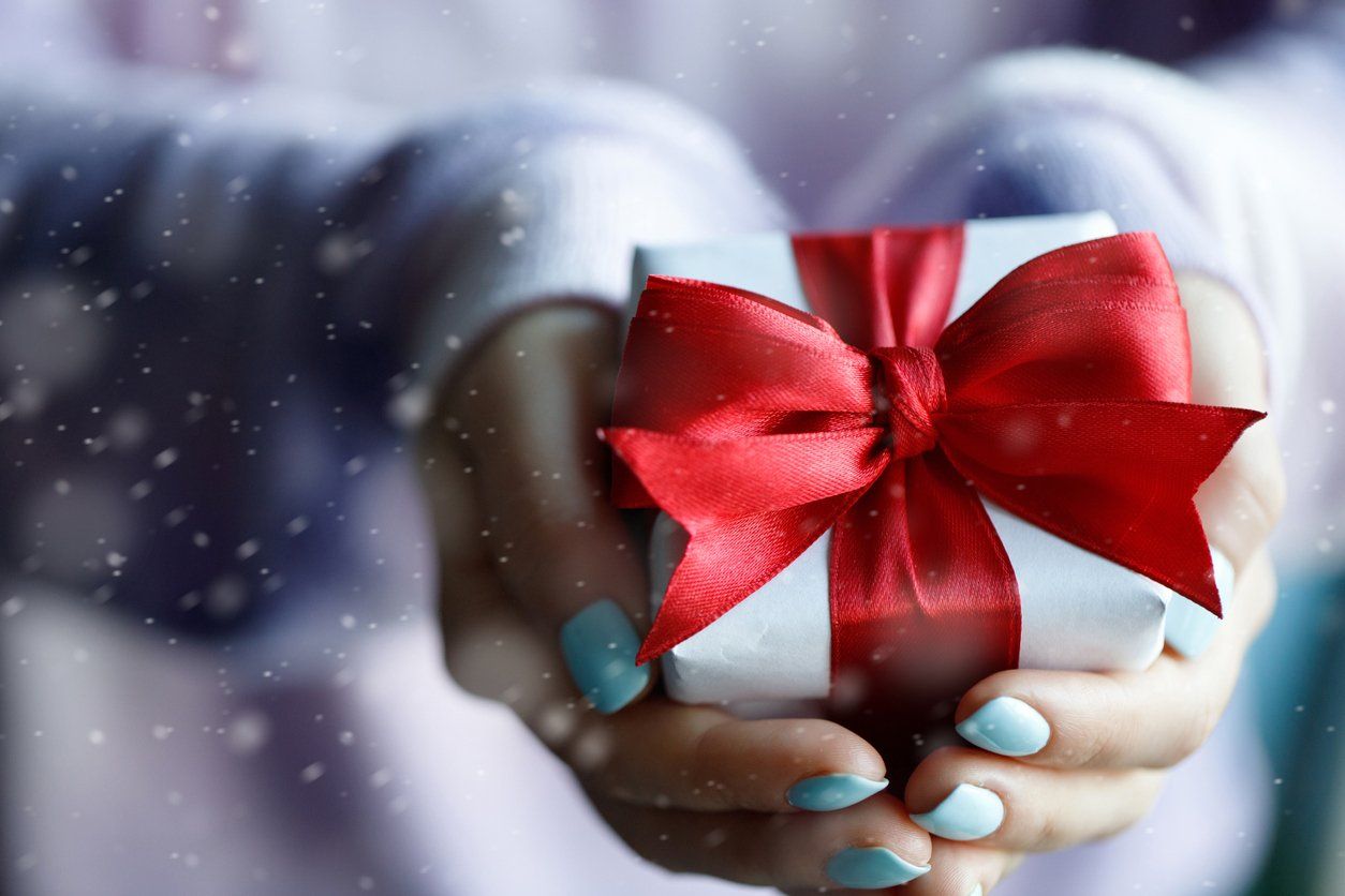 hands holding gift wrapped in red bow