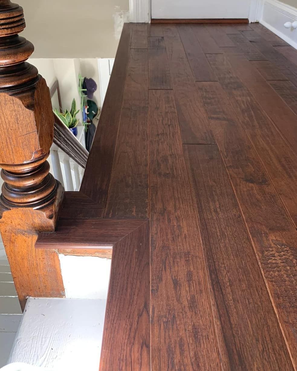 Wooden floor and stair detail. Dark stained wood on stairs and landing. Antique wooden banister.