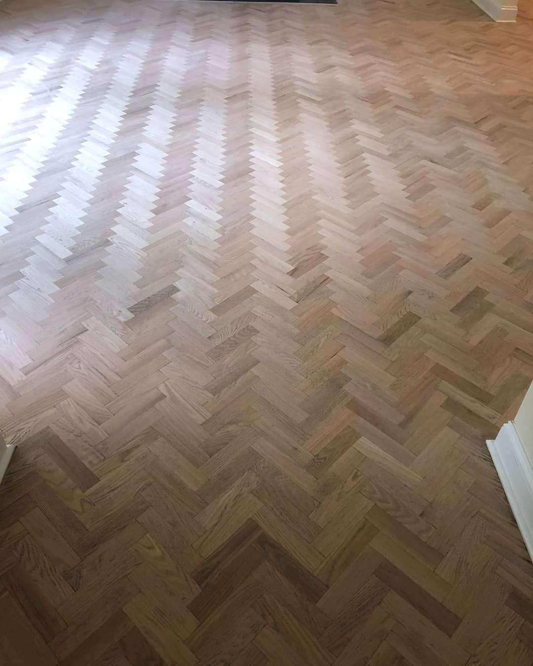 Light-colored herringbone hardwood floor filling a room.
