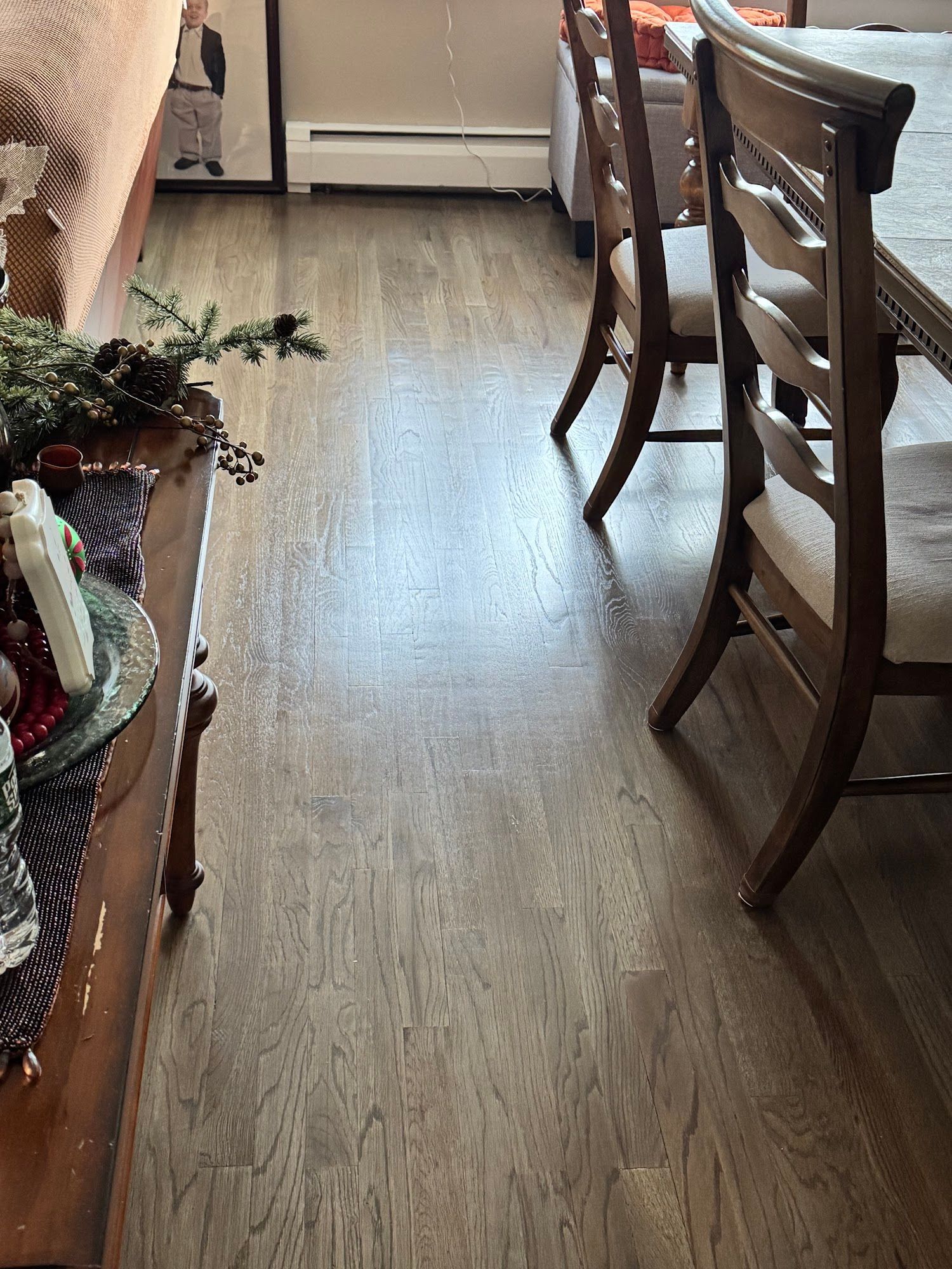 Brown wood floor with dining table and chairs in a well-lit room.