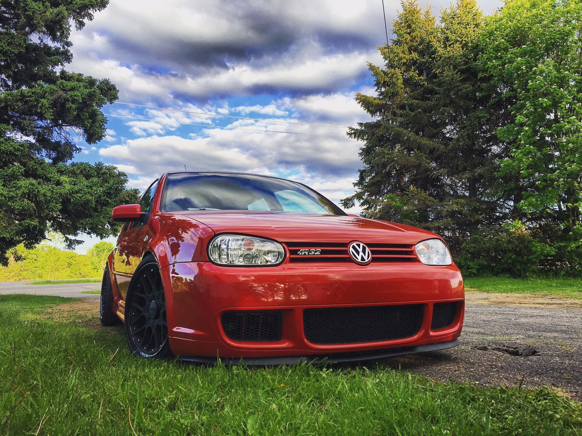 Red Volkswagen GTI Posing On A Scenic Driveway With Blue Sky | Norgren's Auto Center