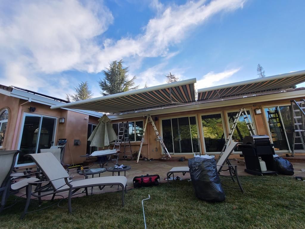 The backyard of a house with a large awning over it.