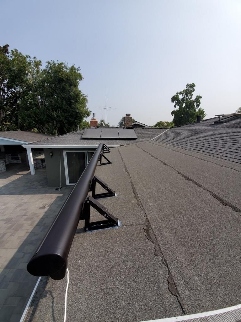 A black pipe is sitting on the roof of a house.