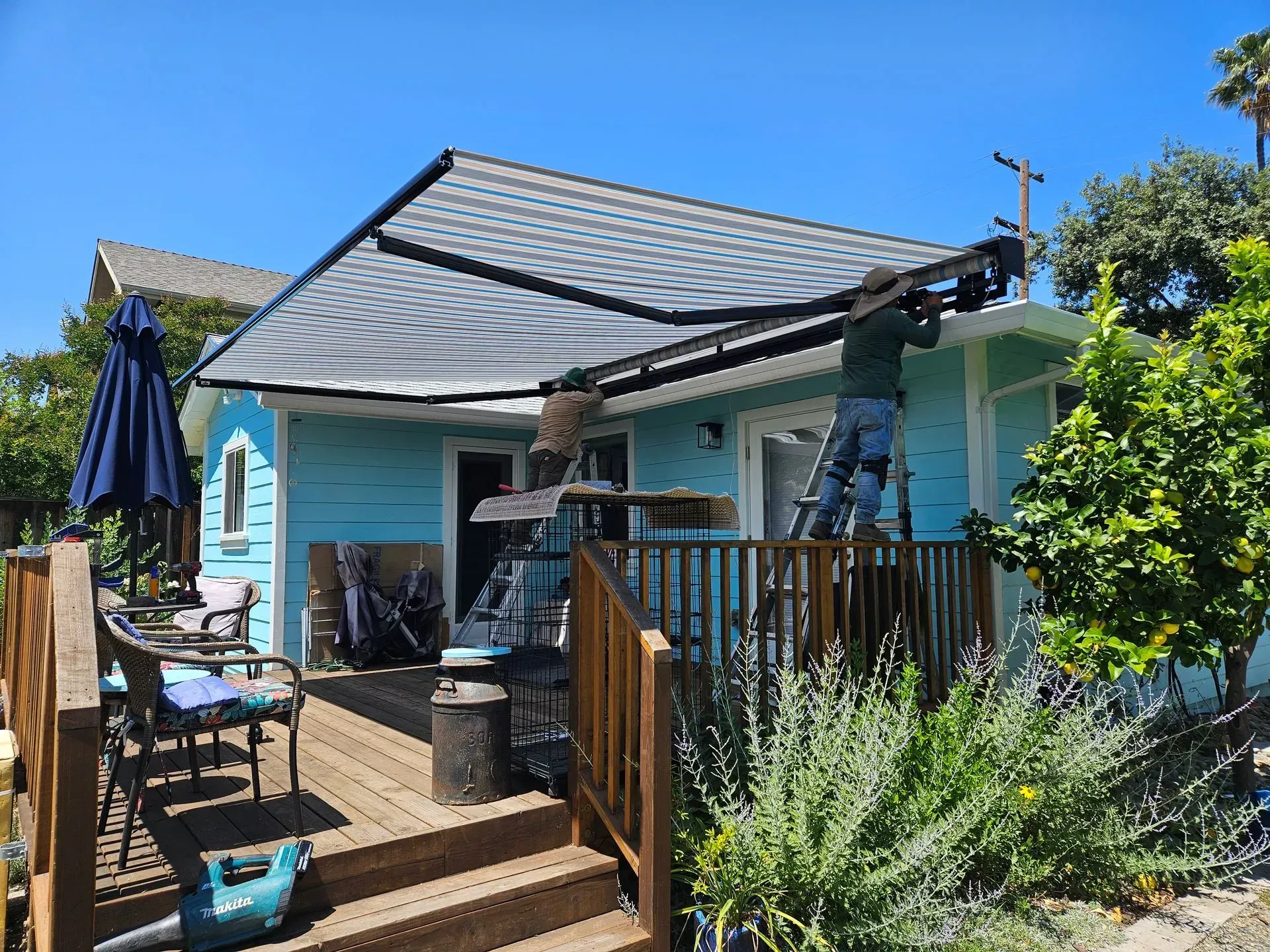 A pergola with a screen on the side of it in a backyard.