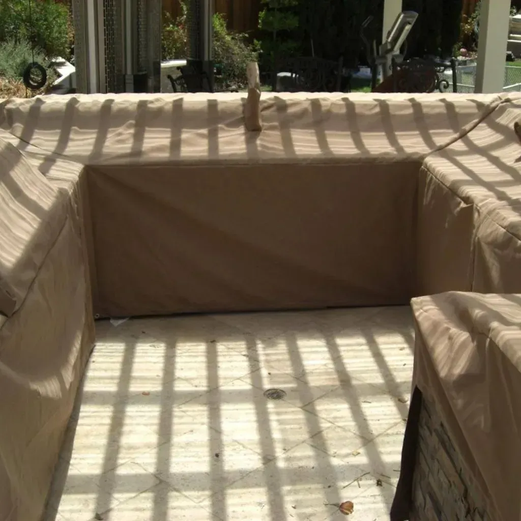 A pergola with a screen on the side of it in a backyard.