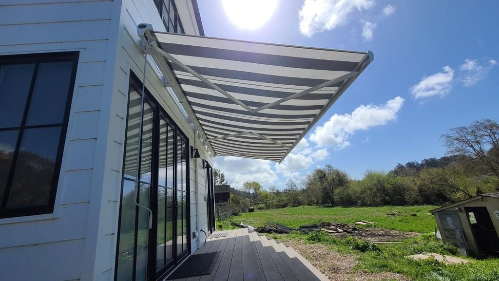 A house with a striped awning on the side of it