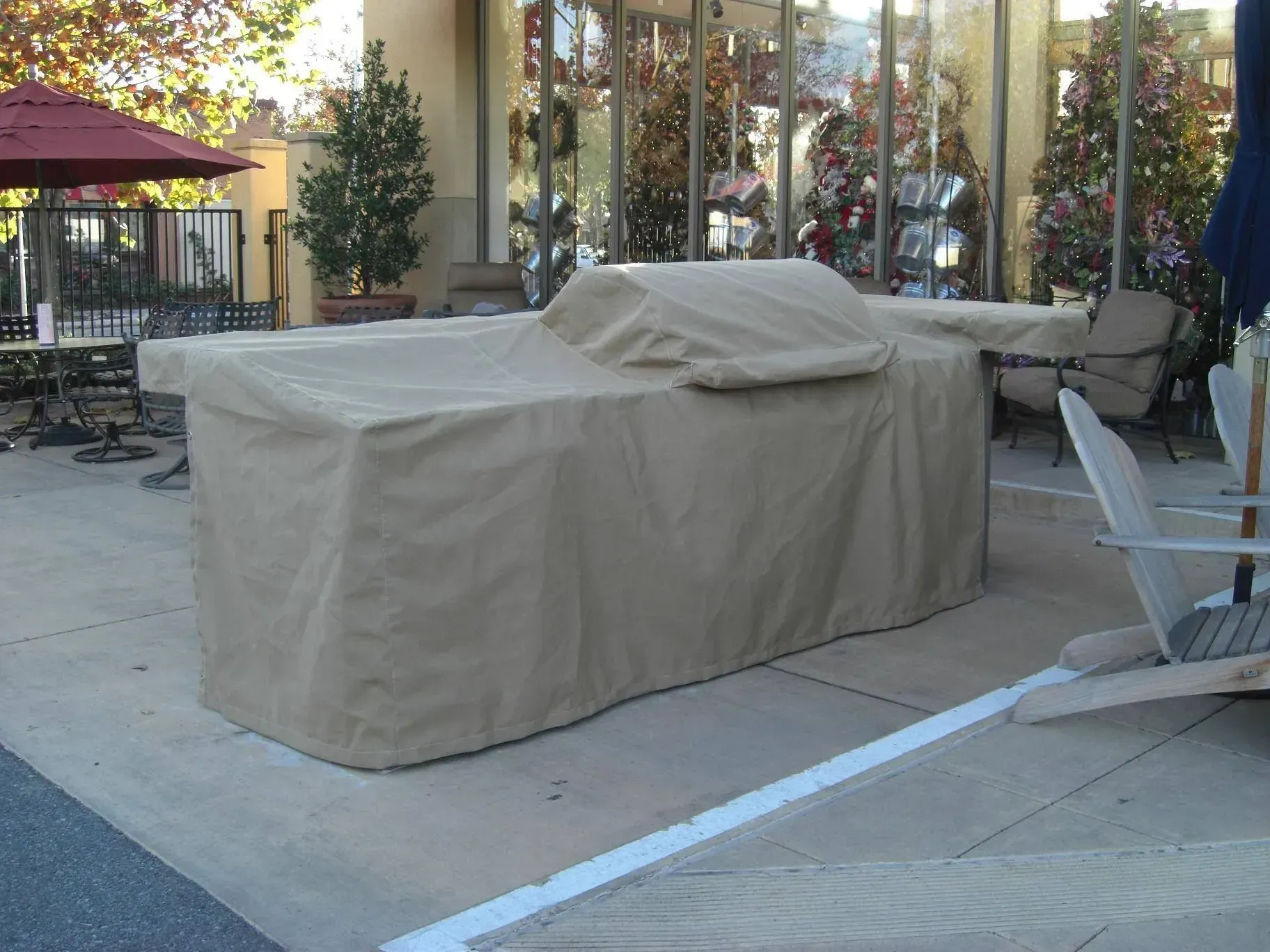 A pergola with a screen on the side of it in a backyard.