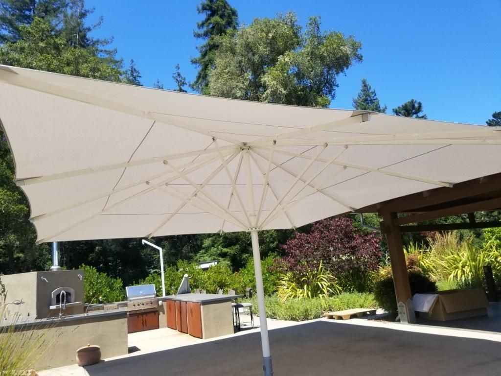 A large white umbrella is sitting on a patio