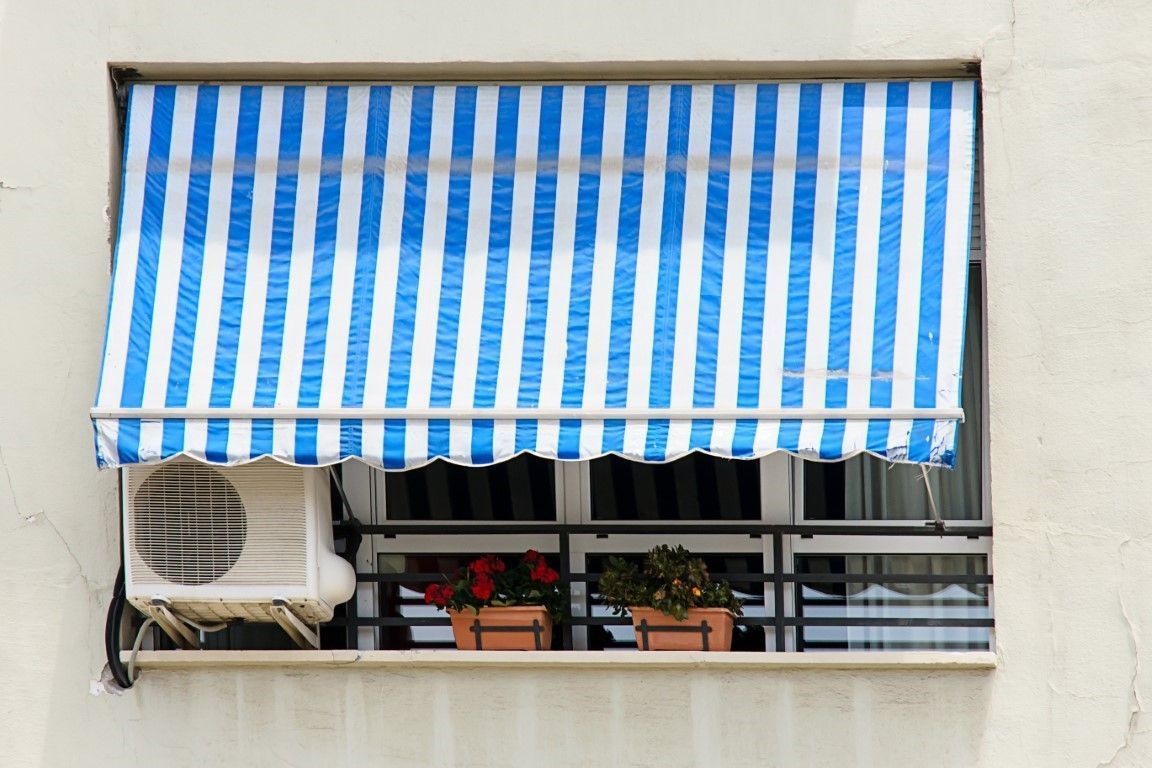 A blue and white striped awning is covering a window.