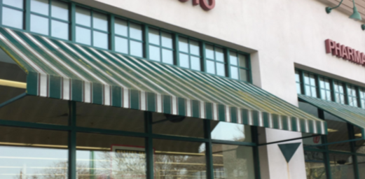 A green and white awning is on the side of a building.