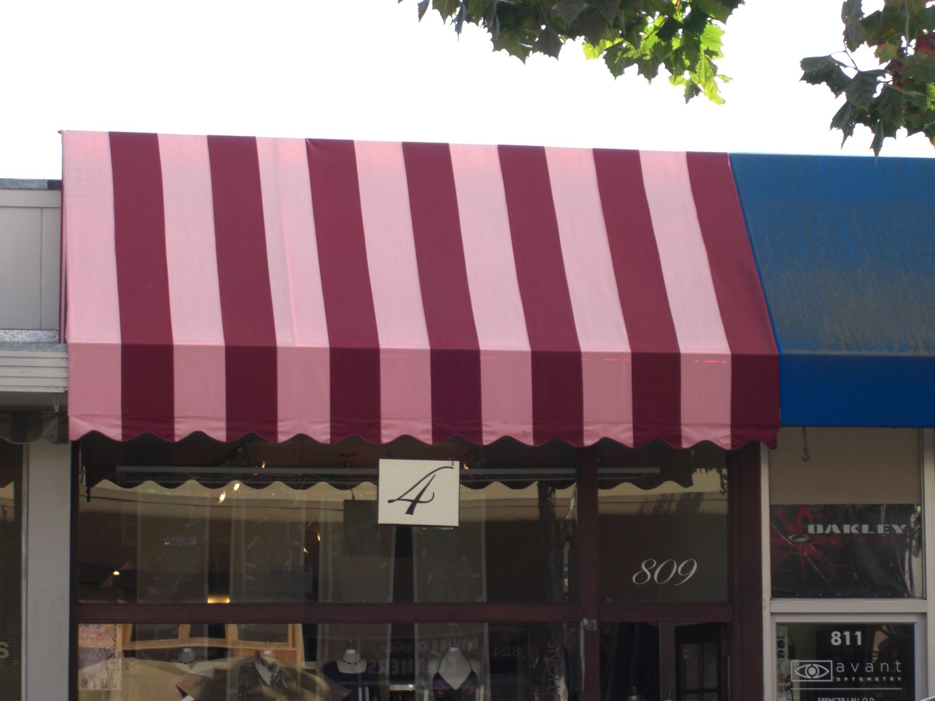 A red awning is hanging over a fence in front of a building