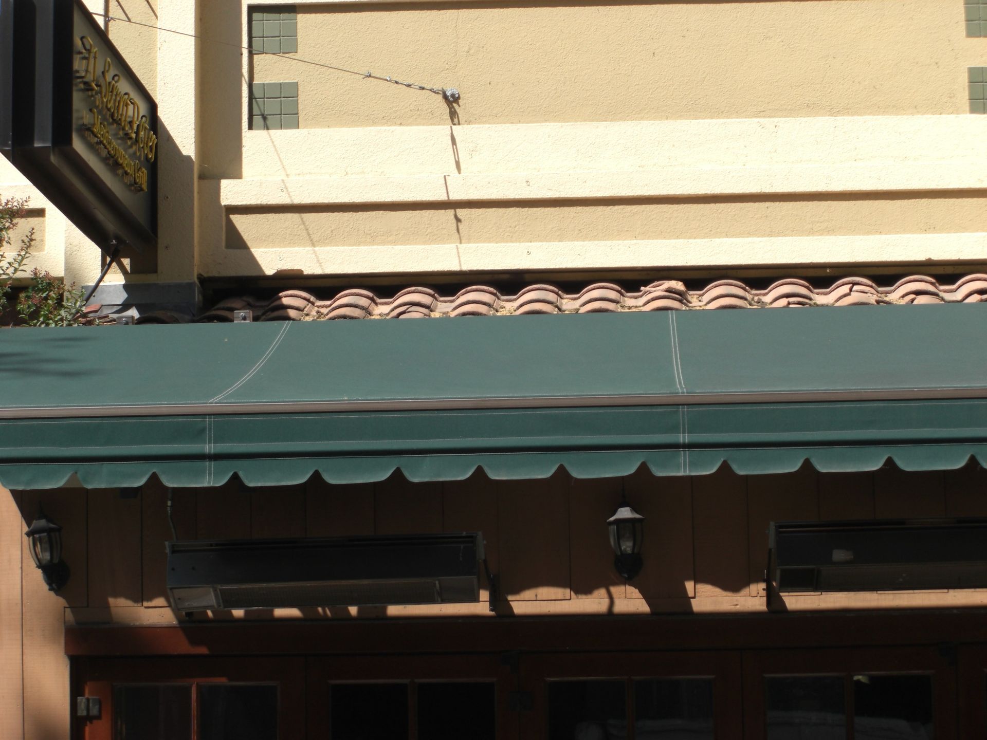 A red awning is hanging from the side of a building