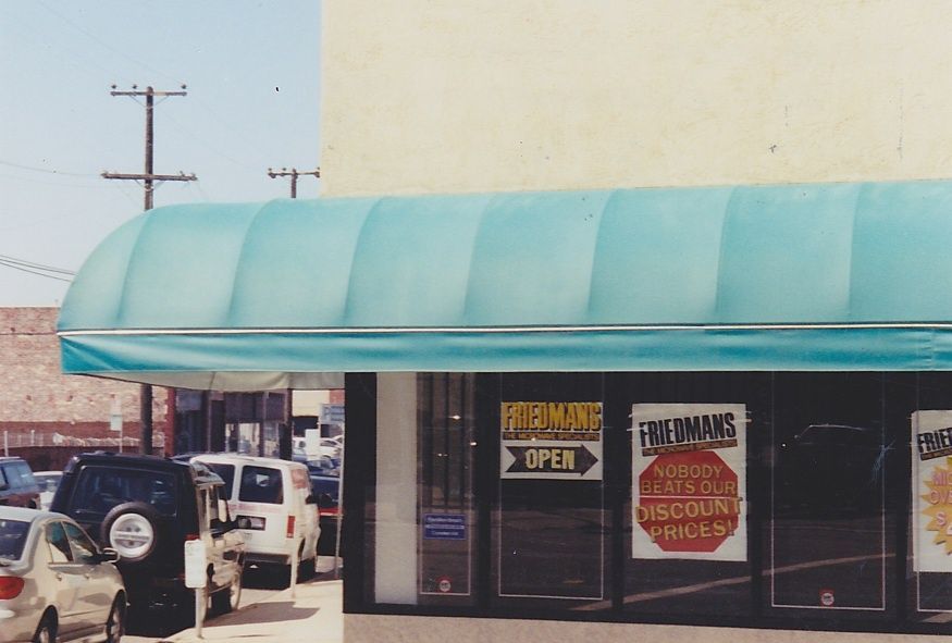 A red awning is hanging over a fence in front of a building