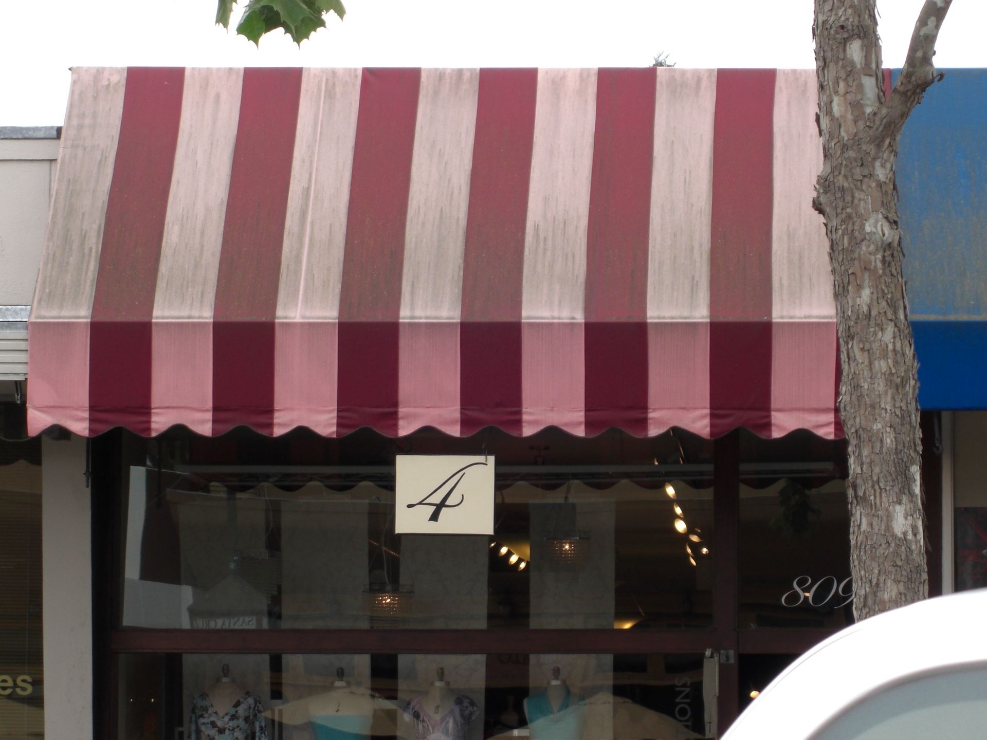 A red awning is hanging from the side of a building