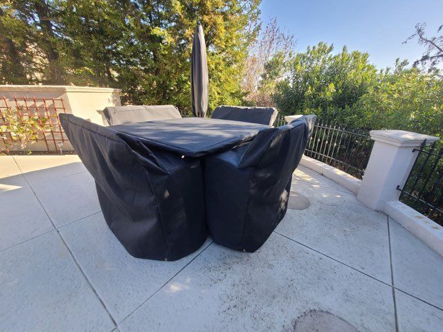 A red awning is hanging over a fence in front of a building
