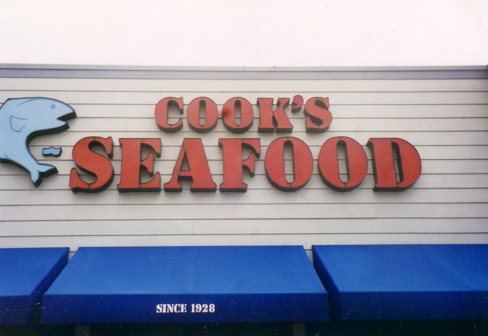 A red awning is hanging over a fence in front of a building