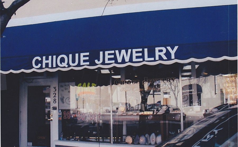 A red awning is hanging over a fence in front of a building