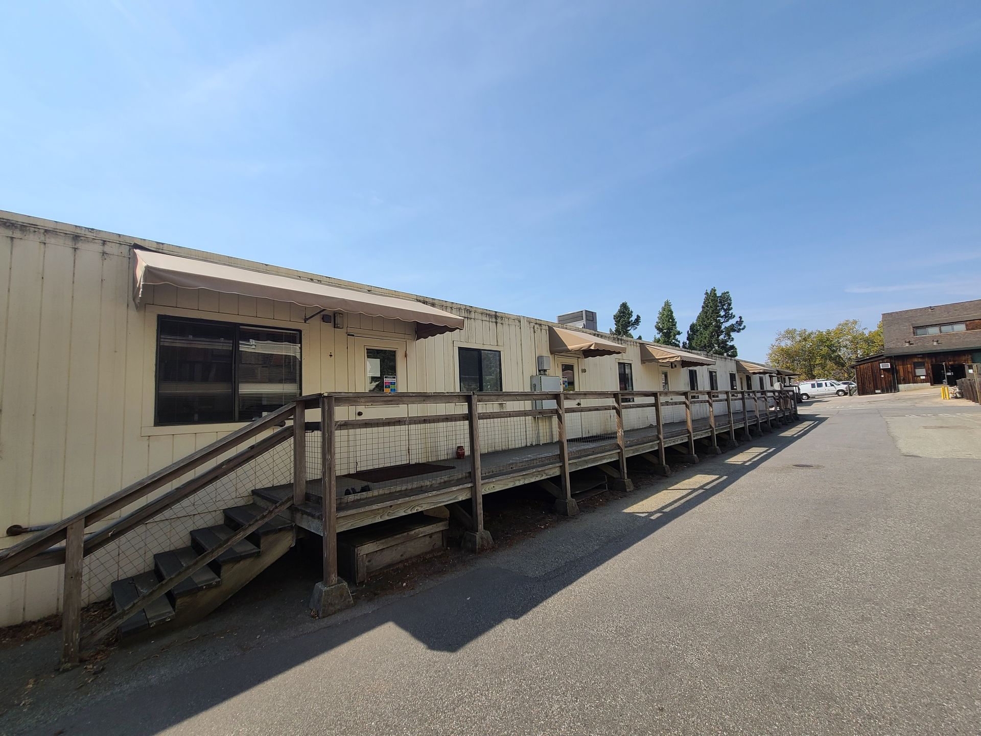 A pink and purple awning is on the side of a building.
