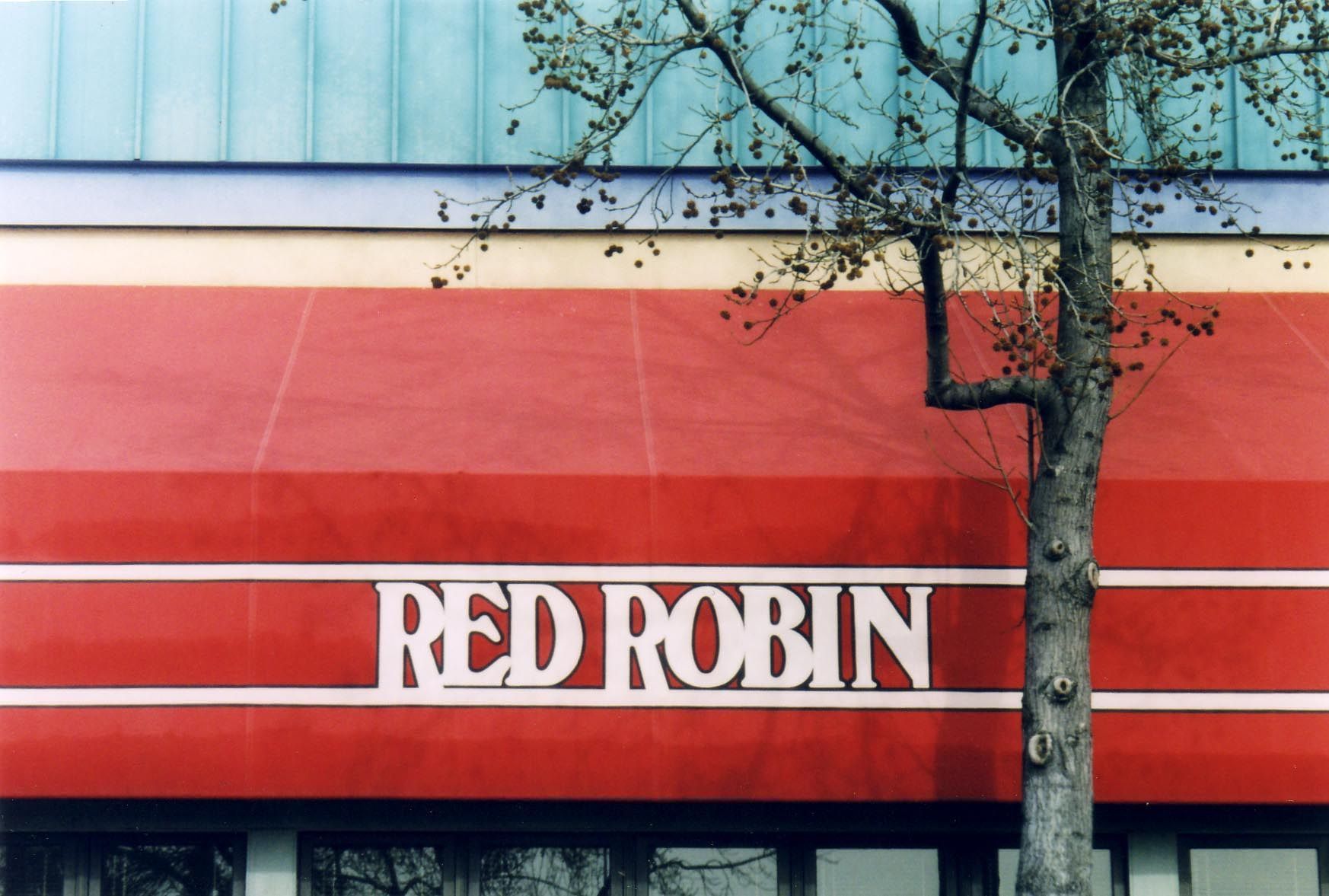 A building with a blue awning over the entrance.