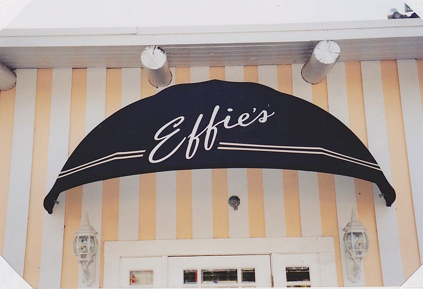 A shadow of a person is cast on a wooden deck