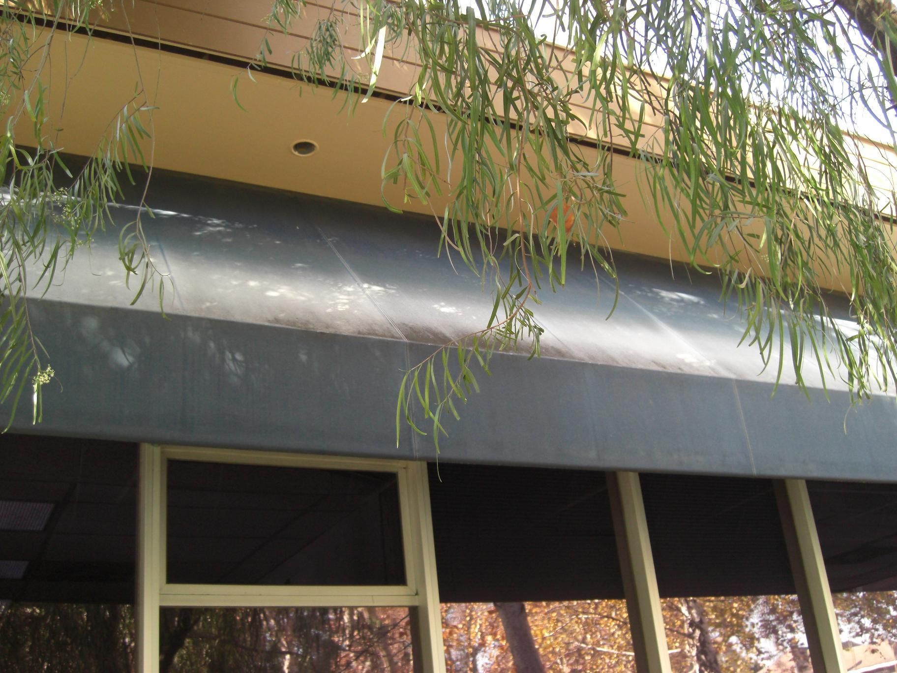 A green and white awning is on the side of a building.