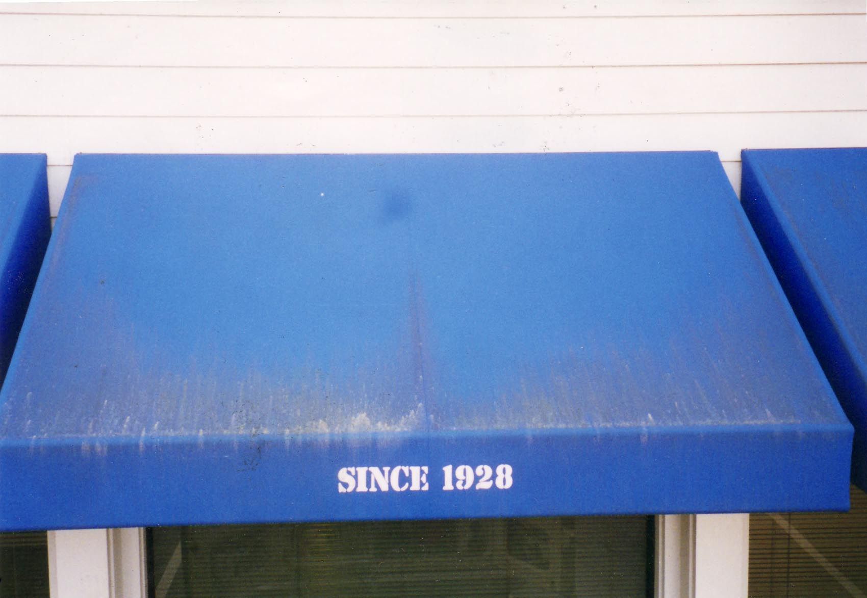 A red awning is hanging from the side of a building