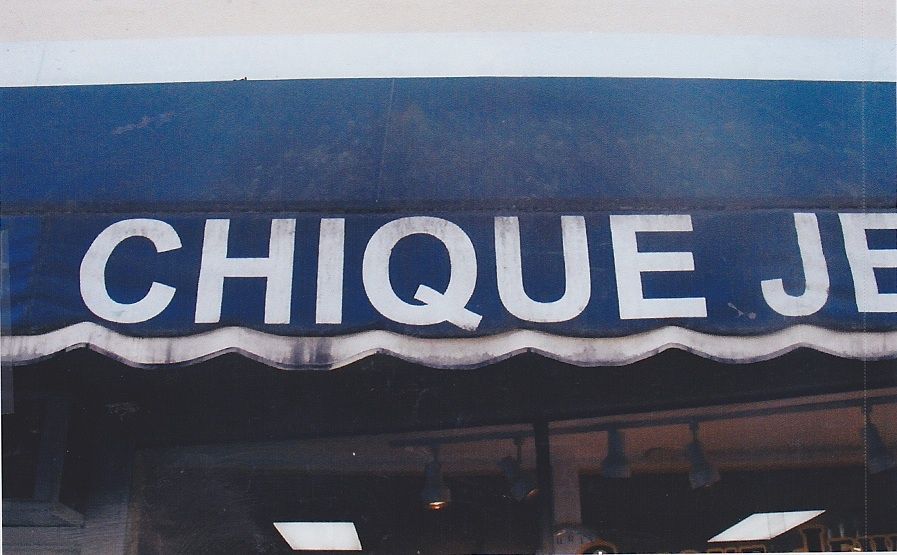 A red awning is hanging from the side of a building