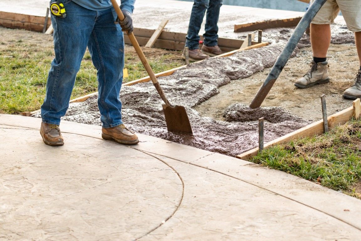 An image of workers spreading out the concrete on the created roadbed.