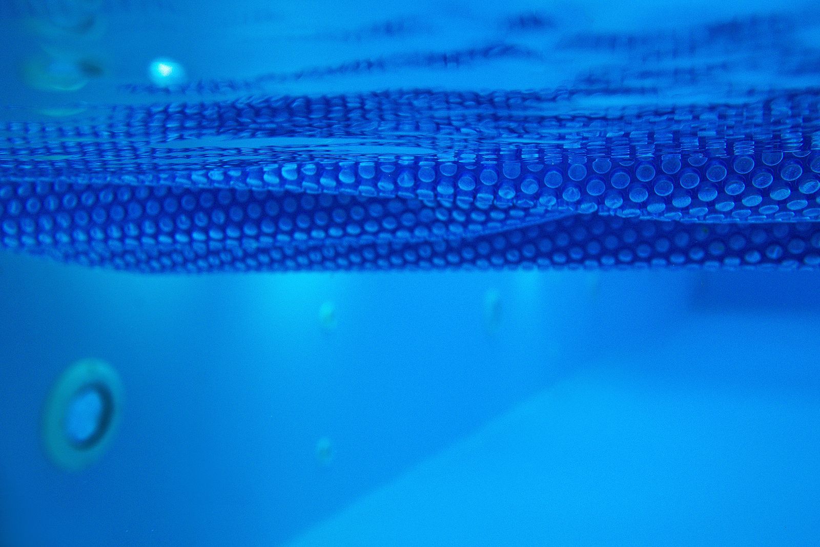 A swimming pool with a life preserver on the side of it.